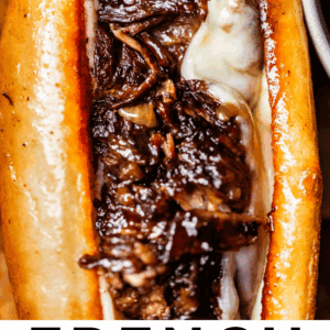 Close-up of a French dip sandwich with melted cheese and juicy shredded beef inside a toasted baguette. Text below reads: French Dip Sandwiches That’ll Knock Your Socks Off – The Food Charlatan.