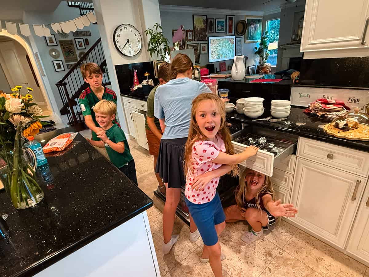 kids unloading the dishwasher in a kitchen.