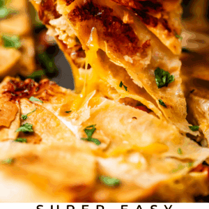 A hand lifting a cheesy slice of sheet pan chicken quesadilla, with melted cheese stretching and fresh herbs on top. Other quesadilla slices are on a tray in the background. Text reads: Super Easy Sheet Pan Chicken Quesadillas.