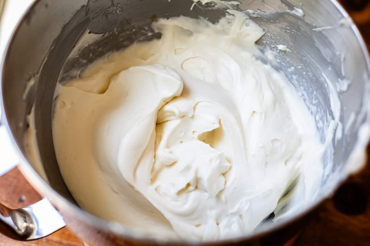 metal mixing bowl holding cream cheese frosting and no beaters showing.