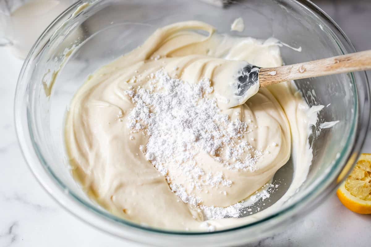 powdered sugar added to the top of the frosting to be mixed in.