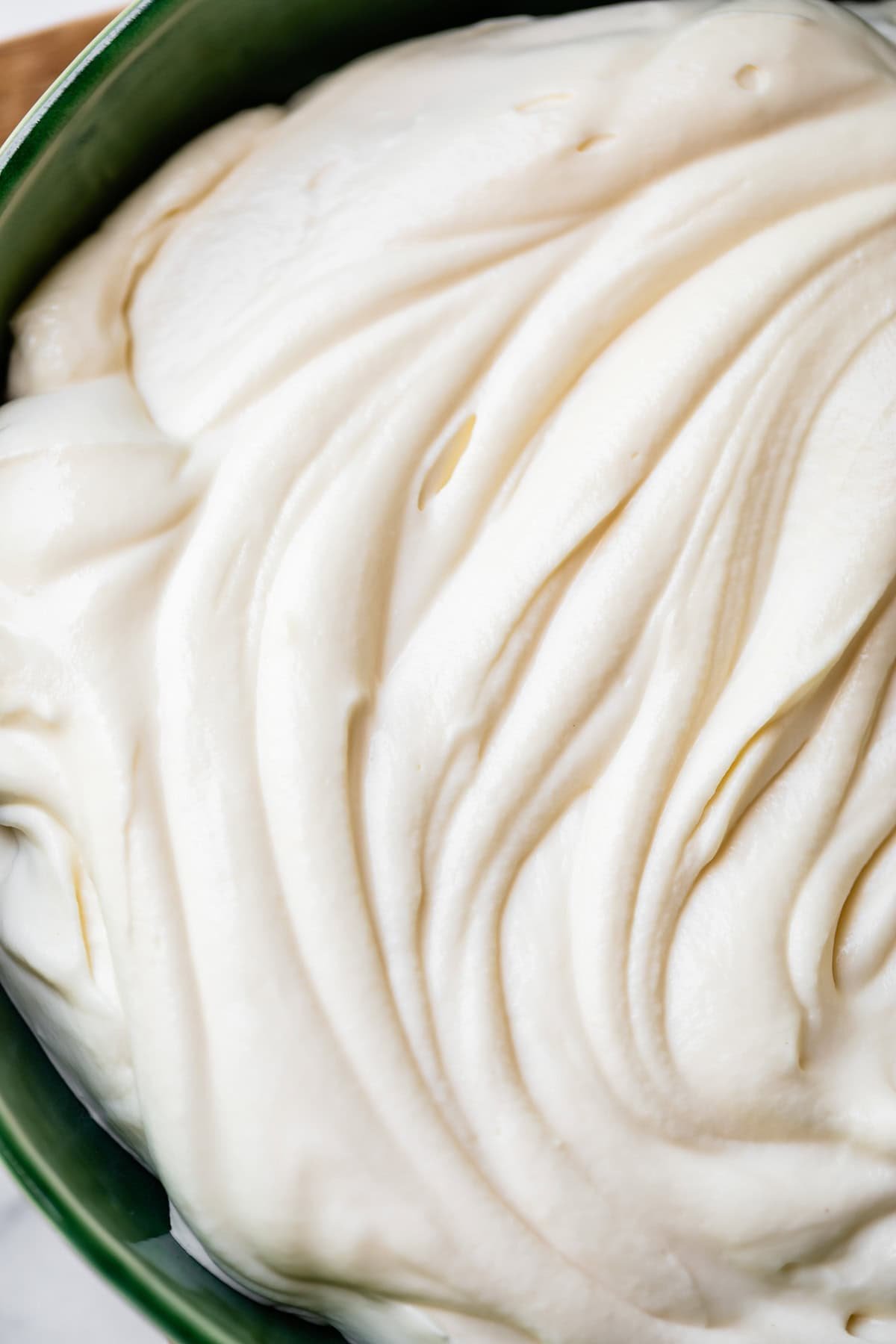 cream cheese frosting with the consistency of whipped cream in a ceramic bowl.