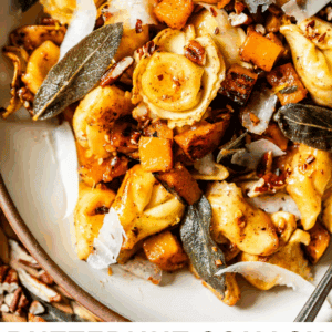A bowl of tortellini topped with roasted butternut squash, crispy sage leaves, shaved cheese, and chopped pecans, all drizzled with browned butter. The text reads: Butternut Squash Tortellini Browned Butter and Sage.
