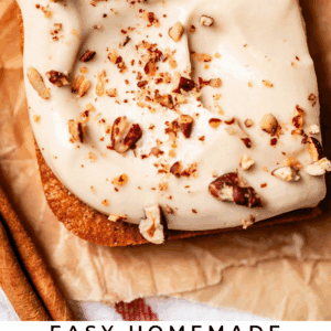 Close-up of two slices of pumpkin sheet cake with creamy frosting and chopped pecans on top, placed on parchment paper. Text at the bottom reads: Easy Homemade Pumpkin Sheet Cake The Food Charlatan.