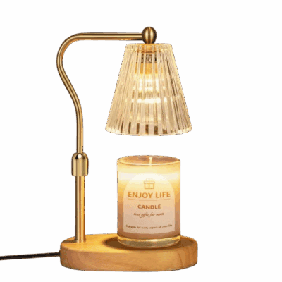 A gold and wood lamp with a glass shade hovers above a lit candle in a glass jar labeled Enjoy Life Candle on a light wooden base, against a plain light background.