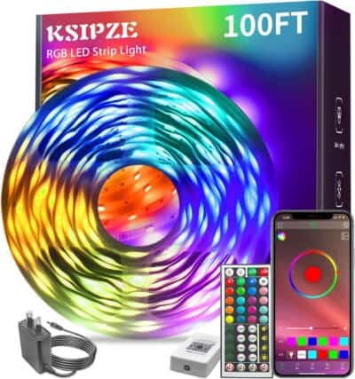 A box of 100-foot KSIPZE RGB LED strip lights with a coiled light strip, remote control, smartphone displaying a color app, power adapter, and control box shown on a white background.