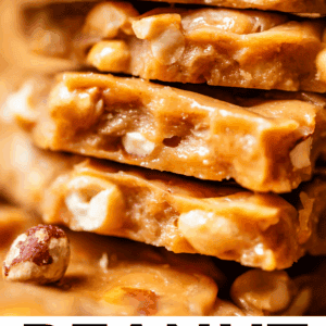 Close-up of stacked pieces of golden peanut brittle, showing crunchy peanuts and glossy, caramelized candy. Text at the bottom reads: Peanut Brittle like Butterfinger Center. The Food Charlatan.