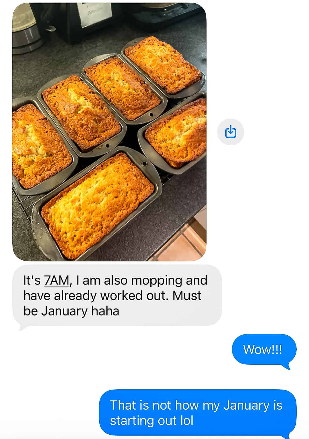 Six freshly baked loaves of bread in pans on a kitchen counter, shown in a text exchange where one person mentions baking, mopping, working out early.