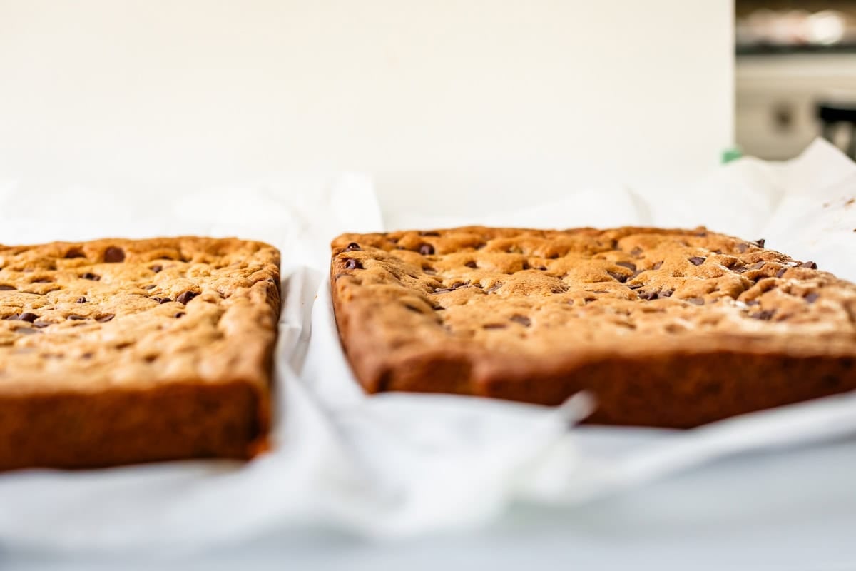 A close up of two pans of cookie bars, one flat, one uneven.