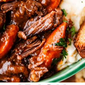 Close-up of Irish beef stew with chunks of beef, carrots, and herbs served over mashed potatoes, with text promoting it as perfect for St. Patrick’s Day by The Food Charlatan.