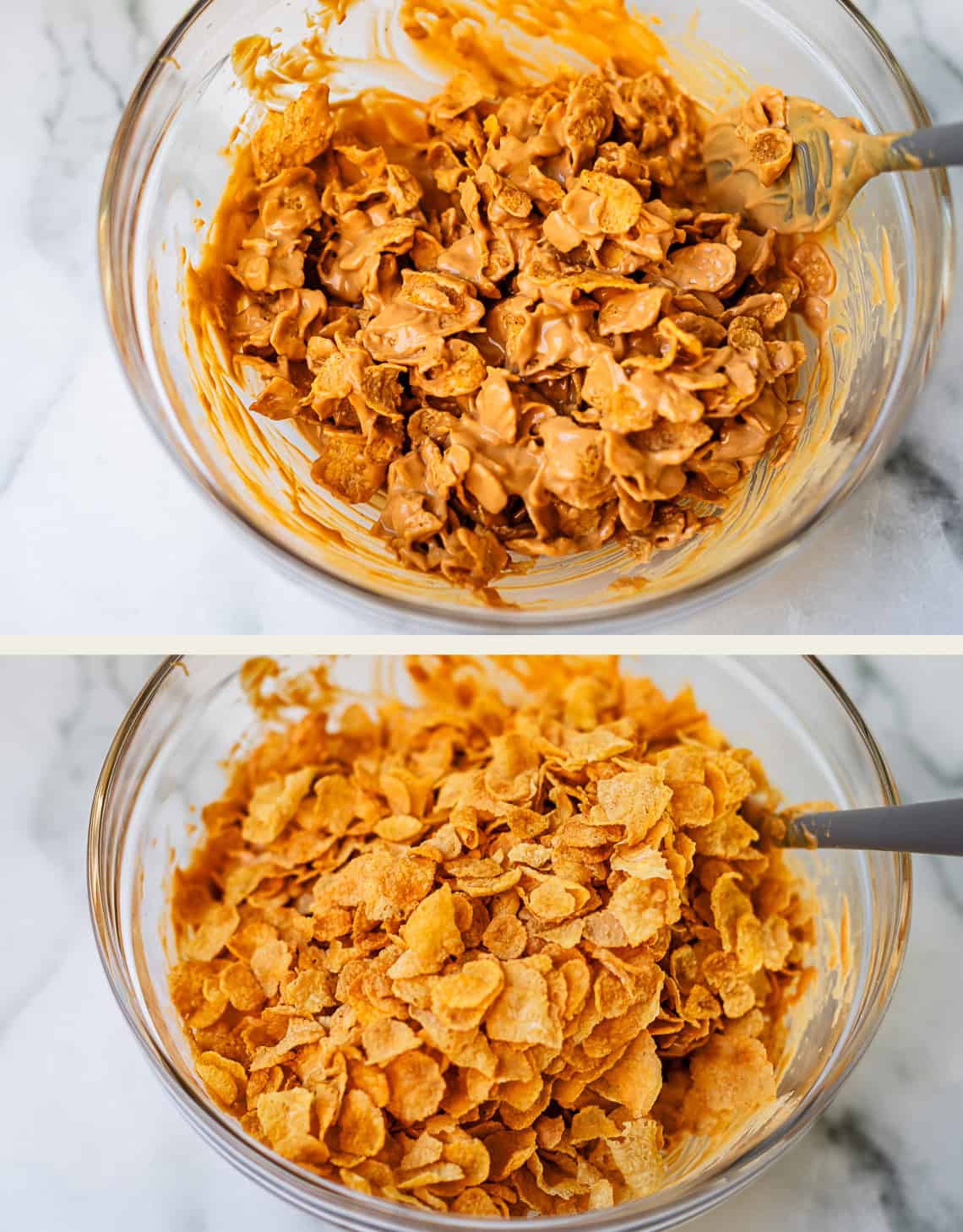 Two glass bowls filled with cornflakes sit on a marble surface. The top bowl shows cornflakes mixed with melted peanut butter, while the bottom bowl contains plain cornflakes. Both have spoons in them.