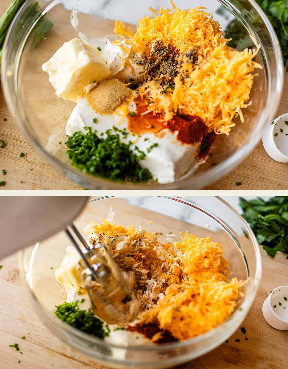 Top image: A glass bowl contains cream cheese, shredded cheddar, butter, chopped green onions, spices, and seasonings. Bottom image: A hand mixer begins blending the ingredients in the same bowl on a wooden surface.