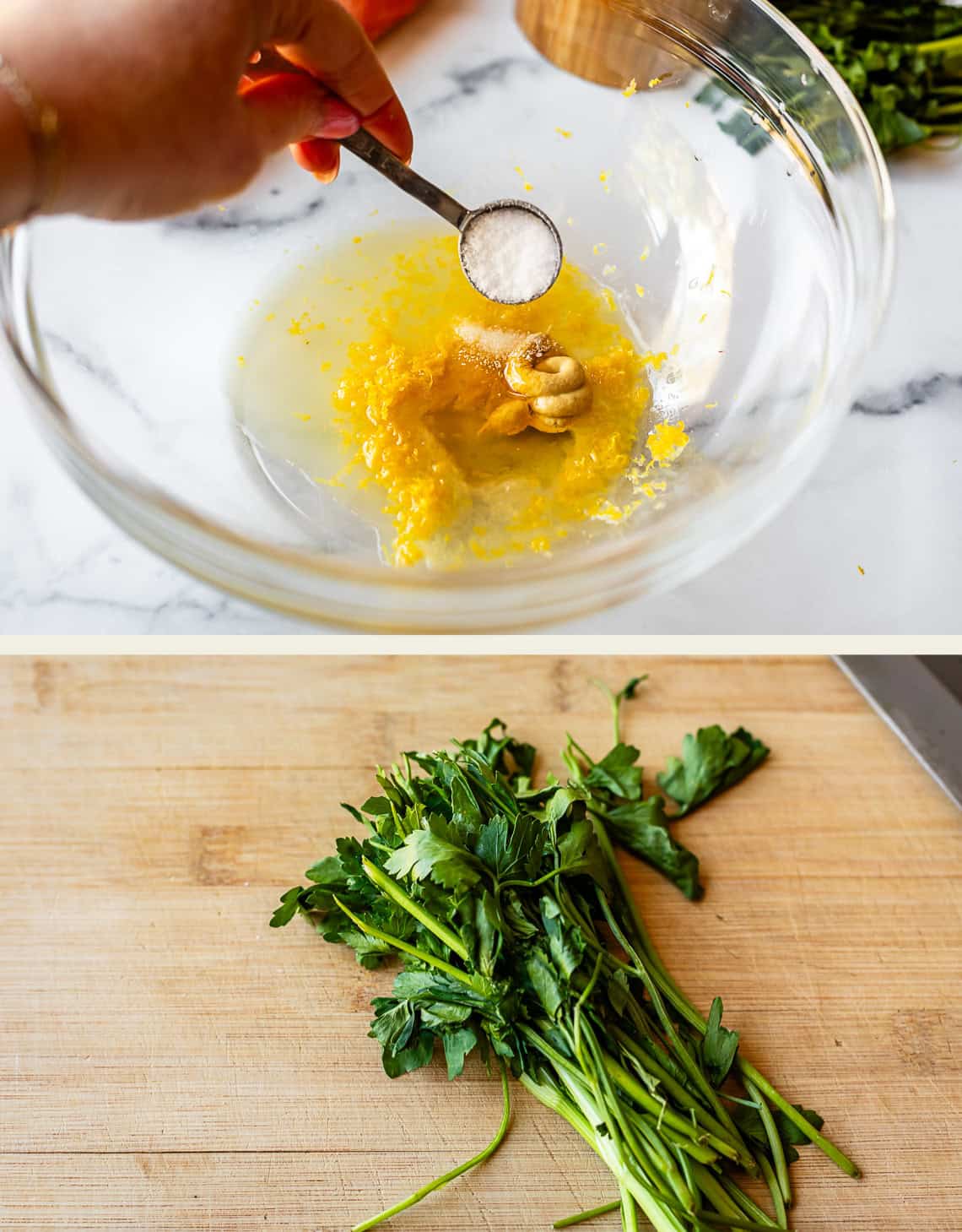 A hand holds a measuring spoon of salt over a glass bowl with lemon juice, lemon zest, and cashews. Below, a bunch of fresh parsley sits on a wooden cutting board.