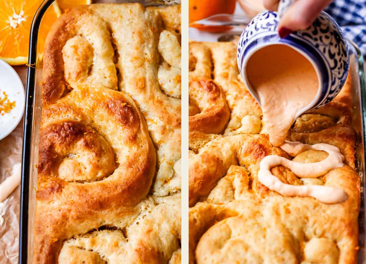 Close-up of golden brown cinnamon rolls in a baking dish. On the right, a hand pours creamy orange glaze from a patterned pitcher onto the fresh rolls. Slices of orange and zest are visible beside the dish.