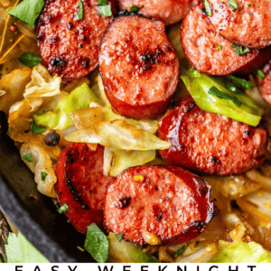 Close-up of sliced kielbasa sausage and cabbage cooked together in a skillet, garnished with fresh herbs. Text below reads: Easy Weeknight Kielbasa Cabbage Skillet - The Food Charlatan.