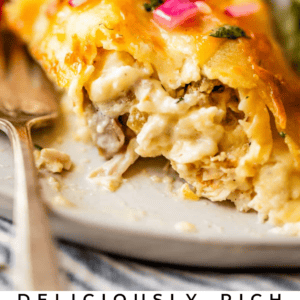 Close-up of a cheesy chicken crepe casserole topped with melted cheese and sliced red onions, with a fork on the side and lettuce in the background. Text at the bottom reads “Deliciously Rich Chicken Crepe Casserole.”.