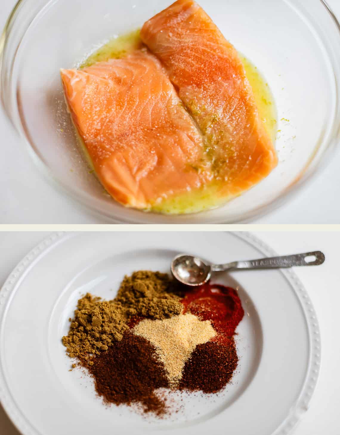 Two raw salmon fillets marinating in a bowl above a plate holding piles of various ground spices and a measuring spoon.