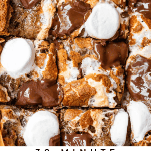 Close-up of gooey smores cookie bars topped with melted chocolate and toasted marshmallows, cut into squares and placed side by side. 30-Minute Smores Cookie Bars text is at the bottom.