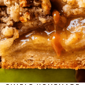 Close-up of a gooey apple pie bar topped with a crumbly streusel and drizzled with caramel sauce. Text at the bottom reads: Simple Homemade Apple Pie Bars - The Food Charlatan..