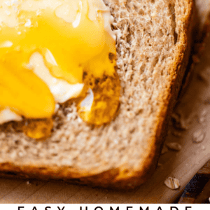 Two slices of whole wheat bread, one topped with melting butter and honey. Text below reads: Easy Homemade Honey Whole Wheat Bread The Food Charlatan..
