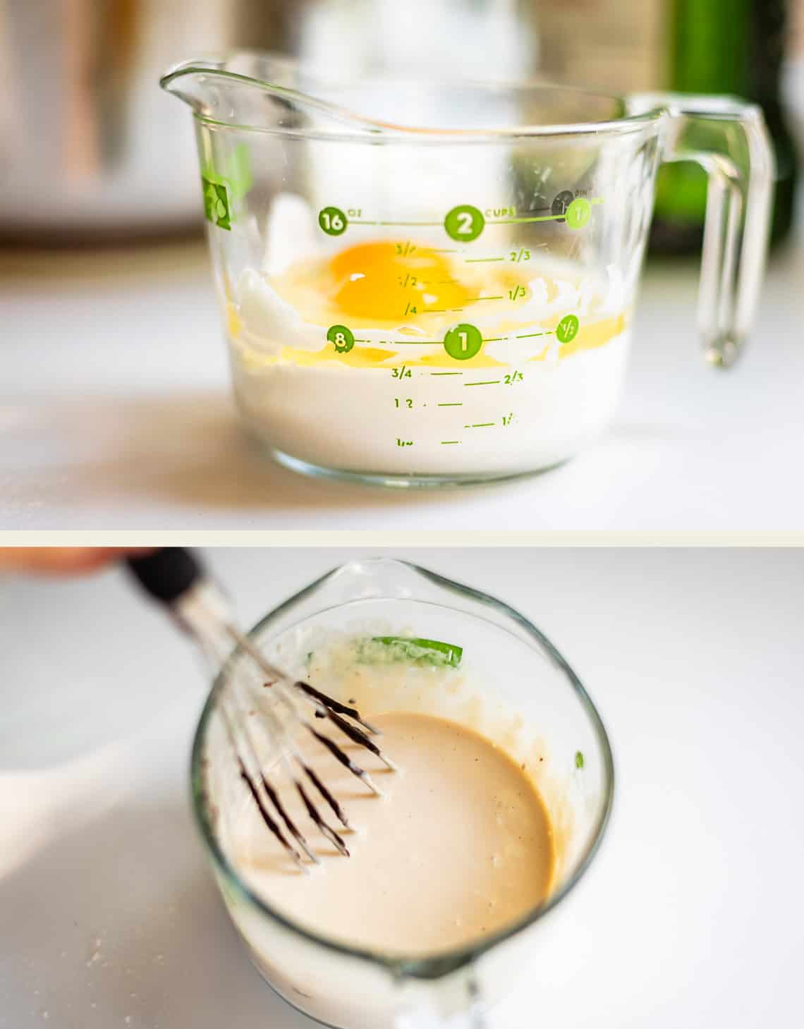 A glass measuring cup containing an egg and flour, and a whisk blending the ingredients into a smooth batter.