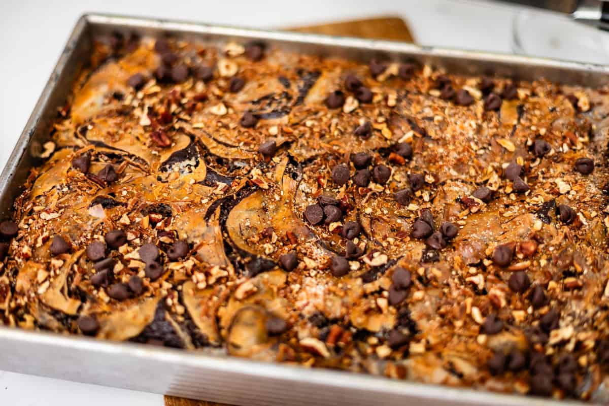 A rectangular pan of brownies topped with chocolate chips and chopped nuts.