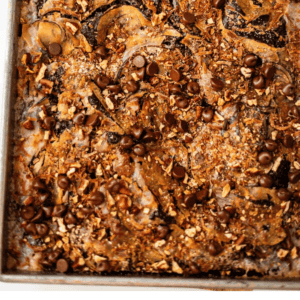 A rectangular pan of chocolate earthquake cake topped with chocolate chips and chopped nuts, with the text Cream Cheese Earthquake Cake underneath.