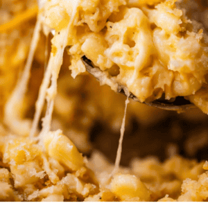 A spoonful of baked macaroni and cheese with melted cheese pull, with text below that says Homemade Mac and Cheese, The Food Charlatan.
